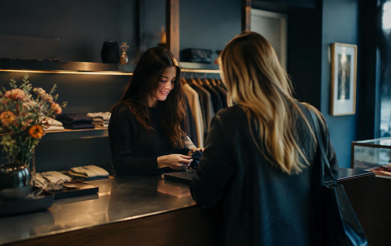 A shop employee helping a customer at the counter